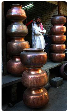 A local copppersmith displays his wares at the central market in Multan